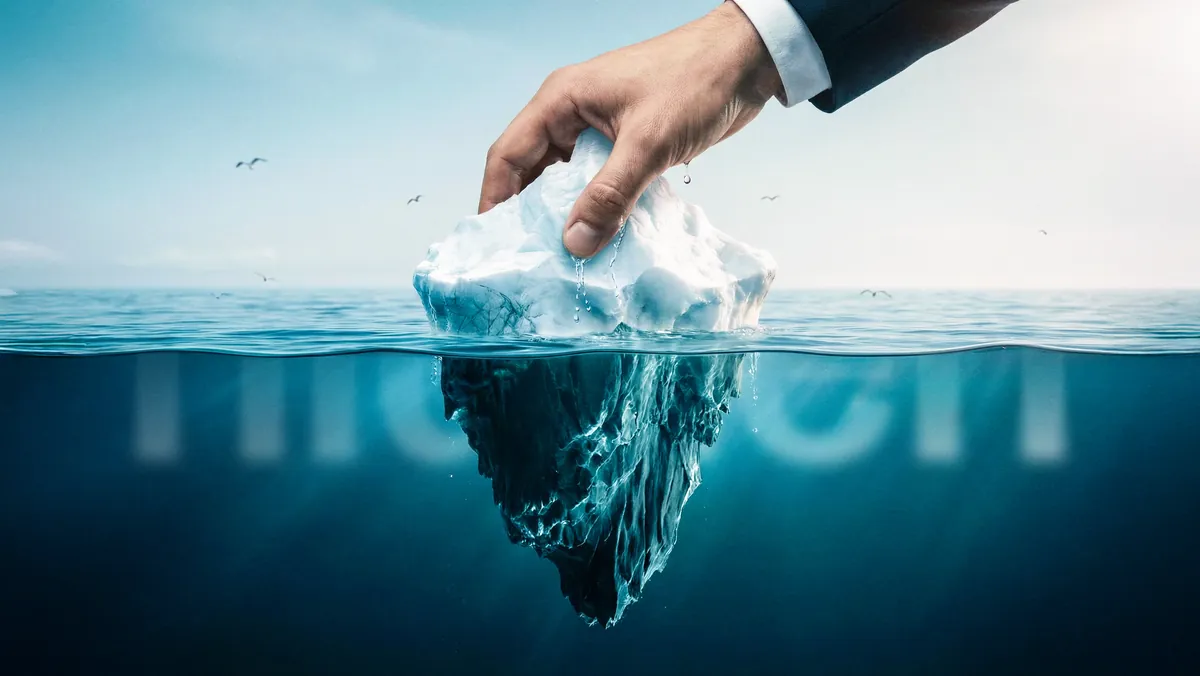 A hand lifting an iceberg out of the ocean symbolizing the hidden job market beneath the surface